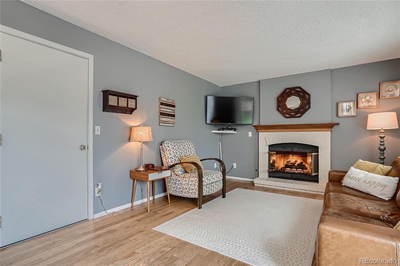 8994 Bermuda Run Circle Highlands Ranch, CO 80130 - Photo 5 of 30 a living room with furniture and a fireplace