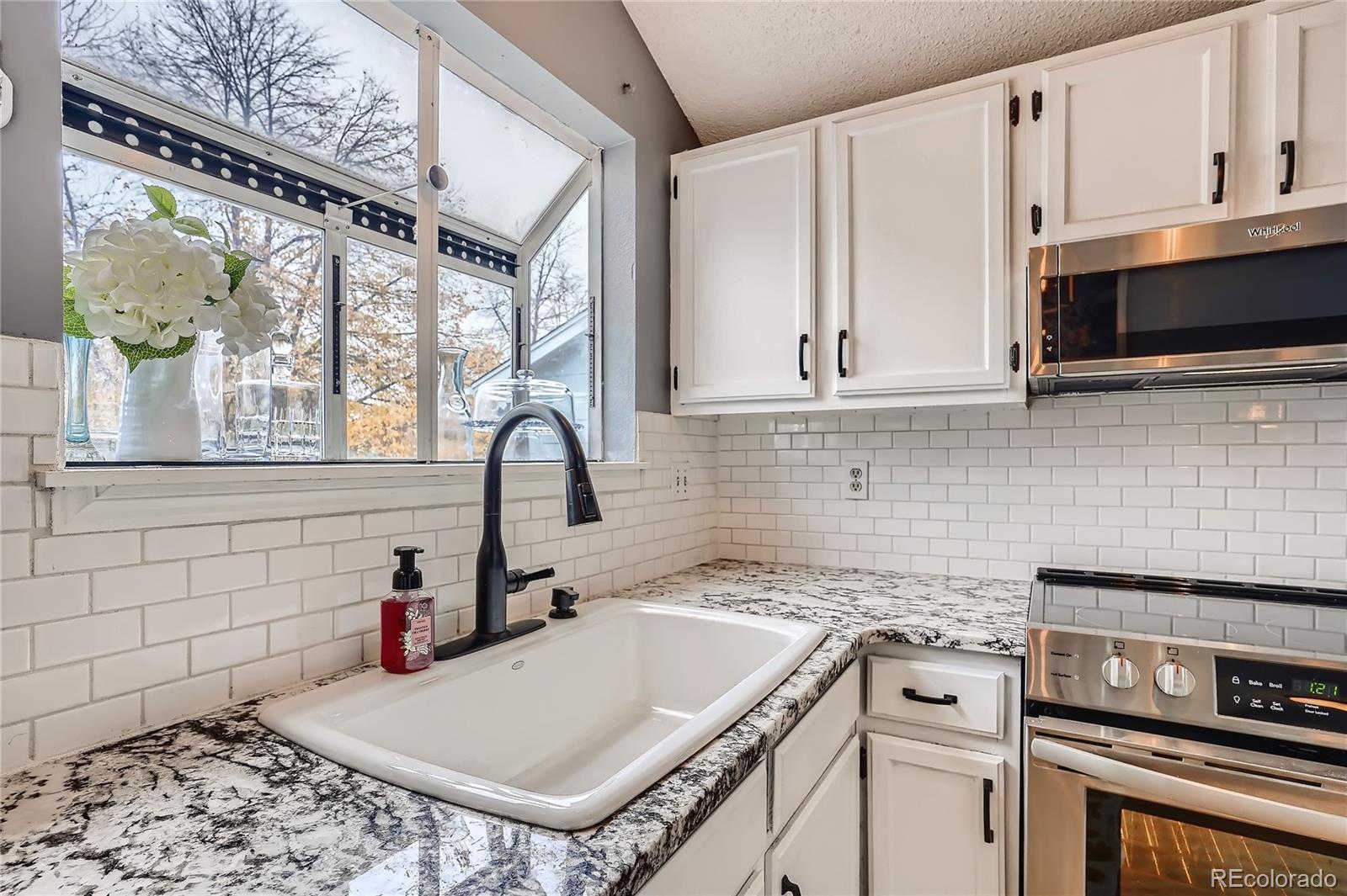 8994 Bermuda Run Circle Highlands Ranch, CO 80130 - Photo 8 of 30 a kitchen with a stove a sink and a microwave