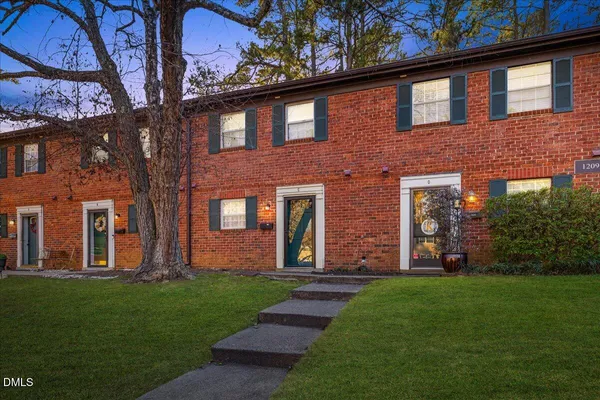 front view of a brick house with a yard
