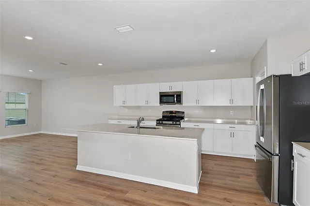 a view of kitchen with stainless steel appliances granite countertop a refrigerator sink and stove