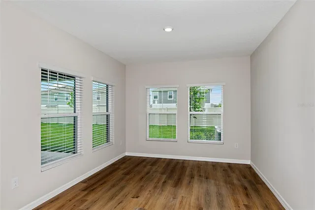 a view of an empty room with wooden floor
