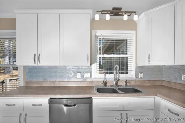 a kitchen with granite countertop white cabinets and a sink