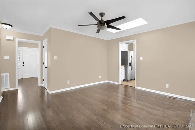 a view of a livingroom with a ceiling fan and wooden floor