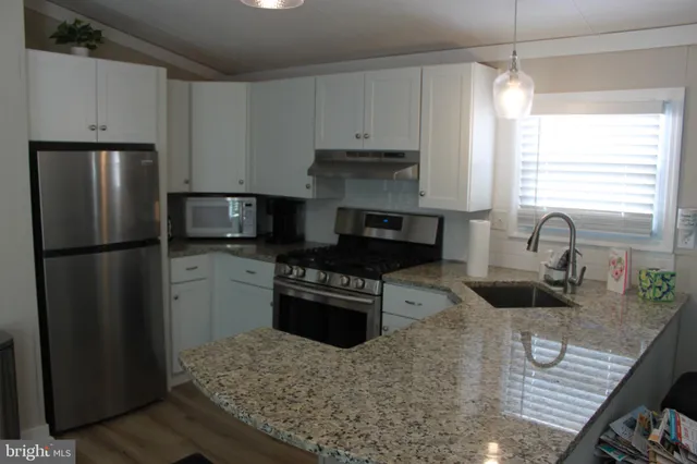 a kitchen with granite countertop stainless steel appliances and wooden cabinets