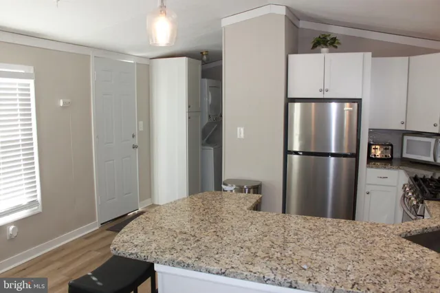 a kitchen with kitchen island a refrigerator sink and stove