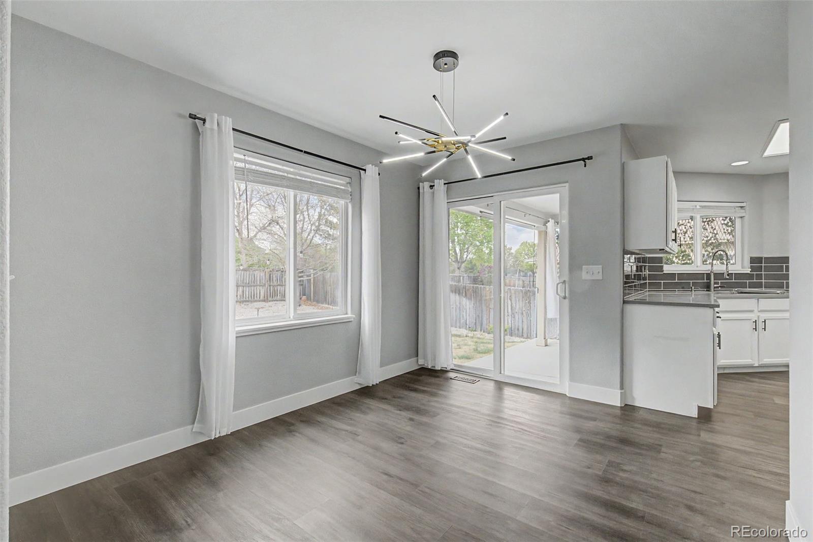 2233 70th Avenue Greeley, CO 80634 - Photo 12 of 50 a view of an empty room with a window and wooden floor