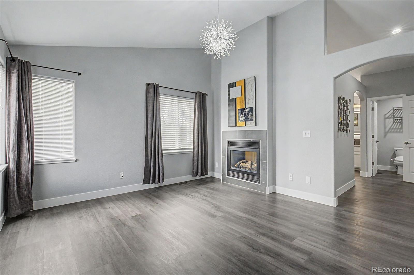 2233 70th Avenue Greeley, CO 80634 - Photo 19 of 50 an empty room with wooden floor chandelier and windows