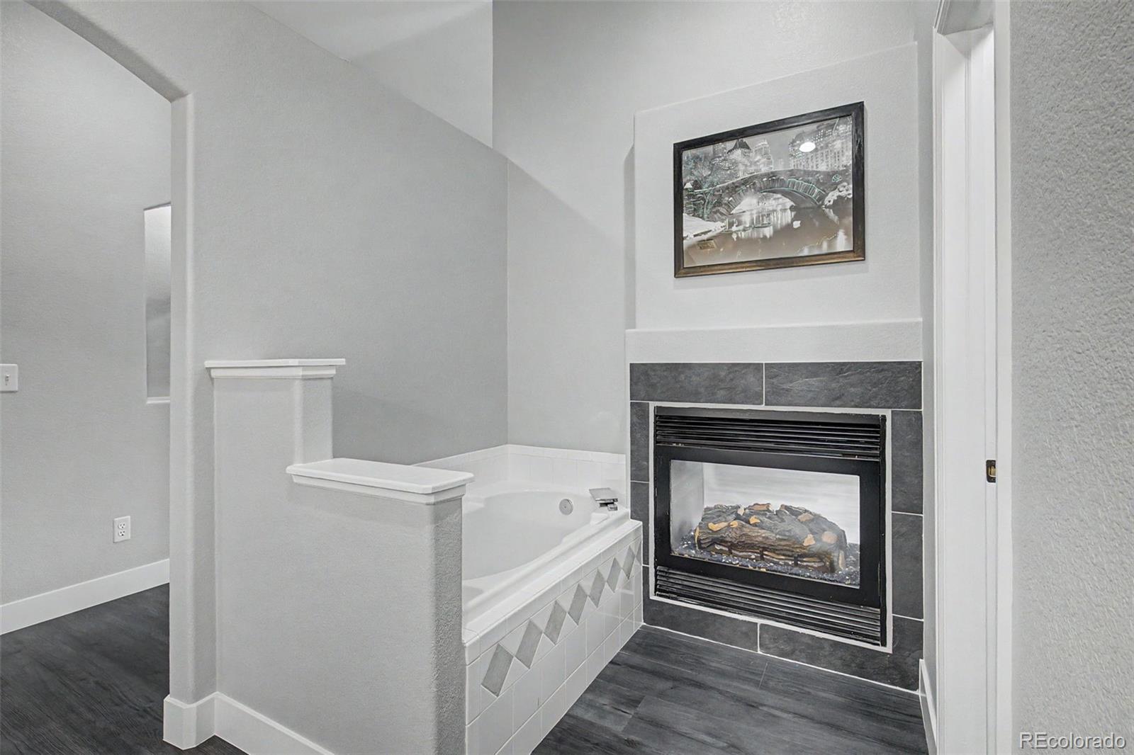 2233 70th Avenue Greeley, CO 80634 - Photo 24 of 50 a hallway with fireplace and wooden floor