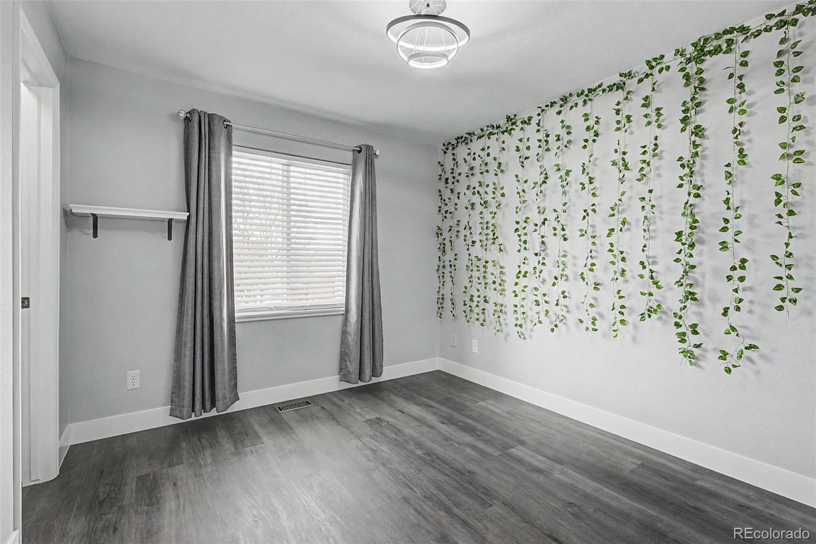 2233 70th Avenue Greeley, CO 80634 - Photo 26 of 50 an empty room with wooden floor and windows