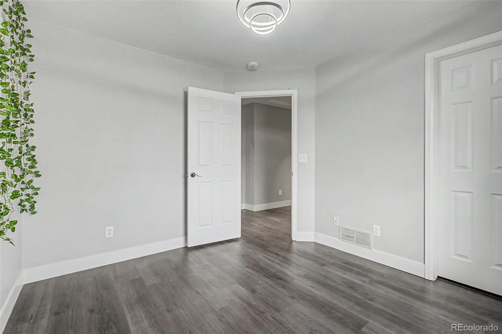 2233 70th Avenue Greeley, CO 80634 - Photo 27 of 50 an empty room with wooden floor and windows