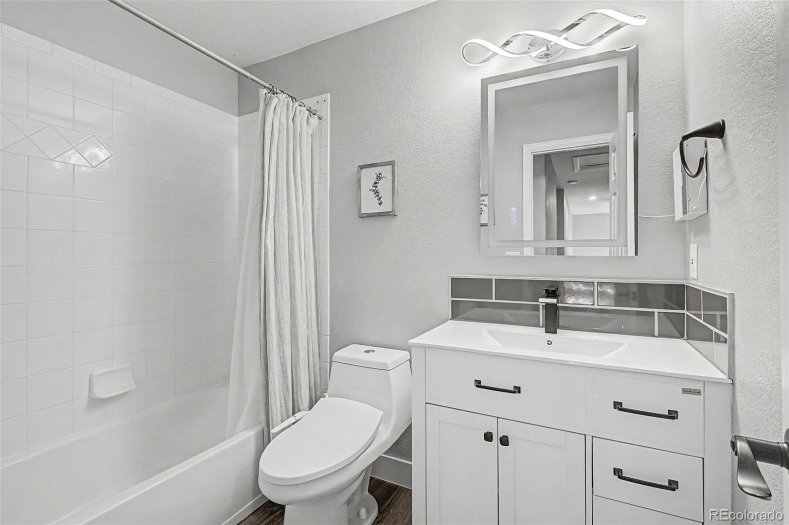 2233 70th Avenue Greeley, CO 80634 - Photo 29 of 50 a bathroom with a sink toilet vanity and shower