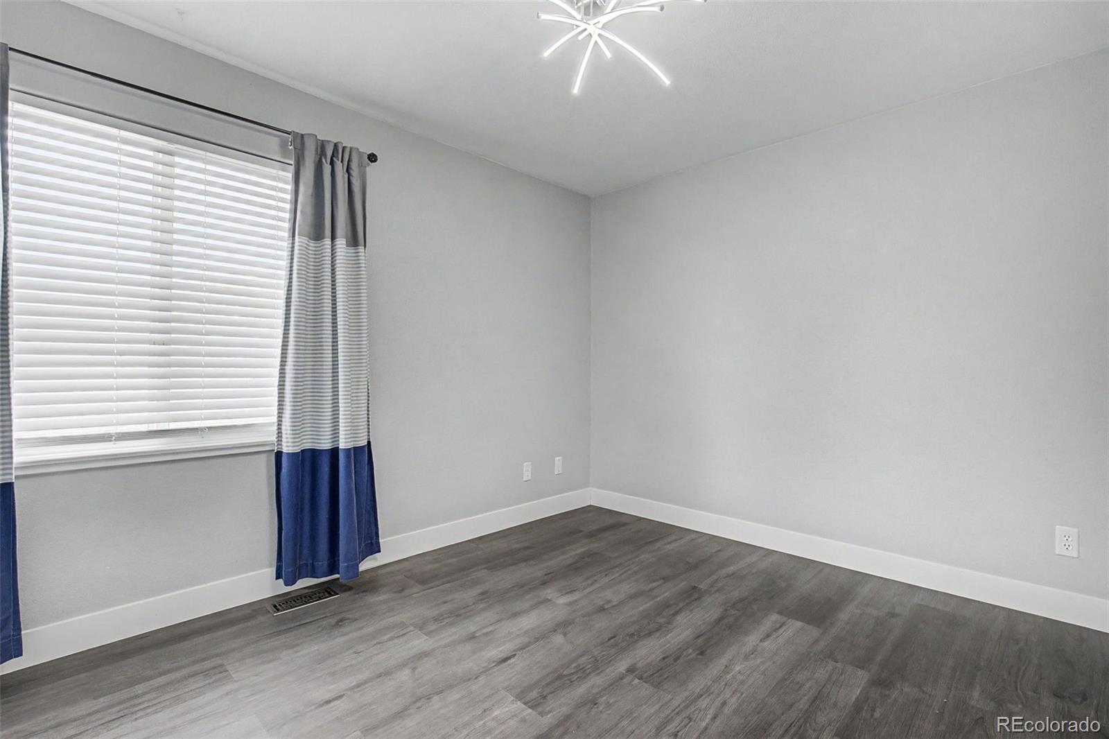 2233 70th Avenue Greeley, CO 80634 - Photo 30 of 50 an empty room with wooden floor and windows