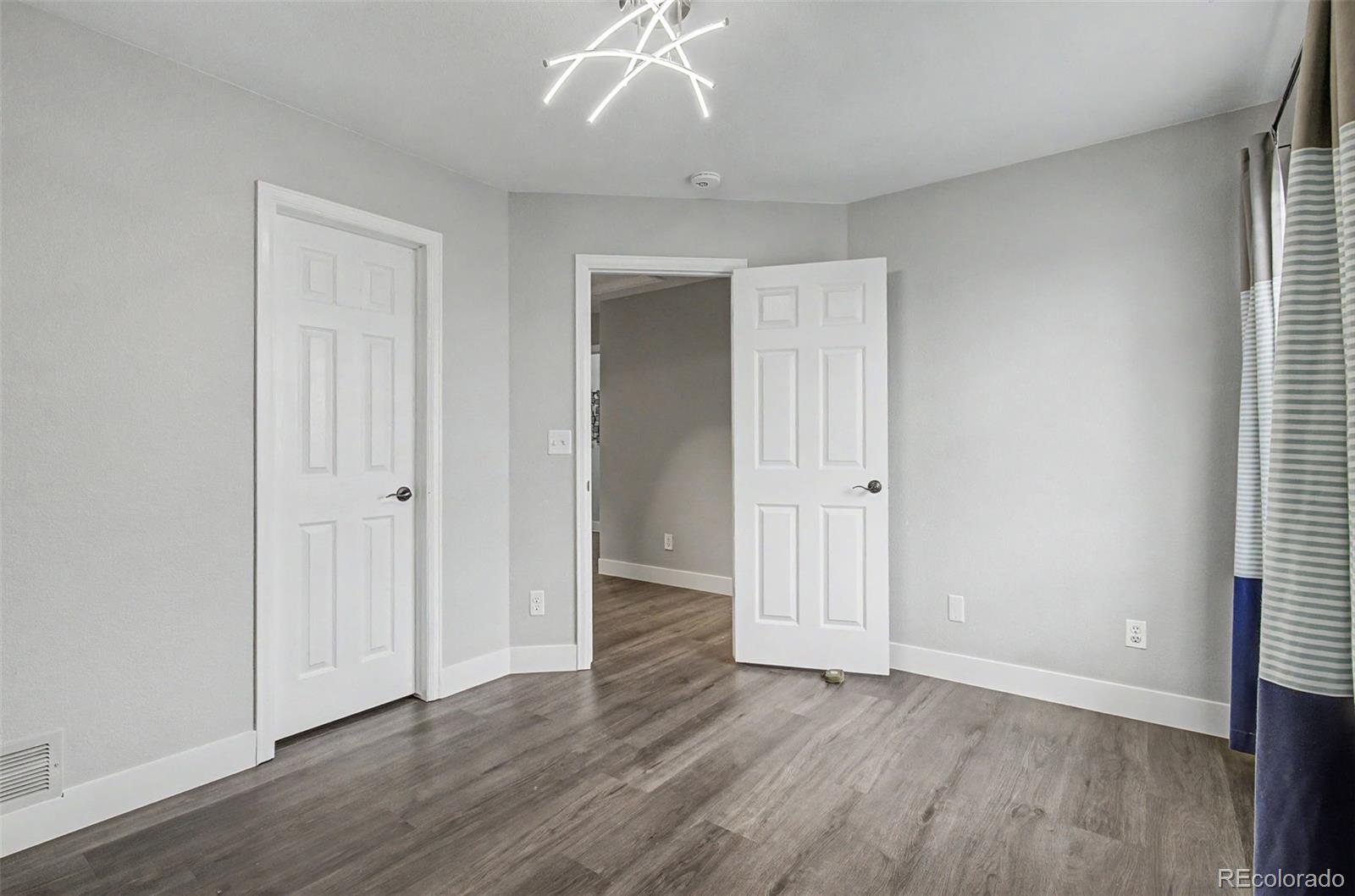 2233 70th Avenue Greeley, CO 80634 - Photo 31 of 50 an empty room with wooden floor and windows