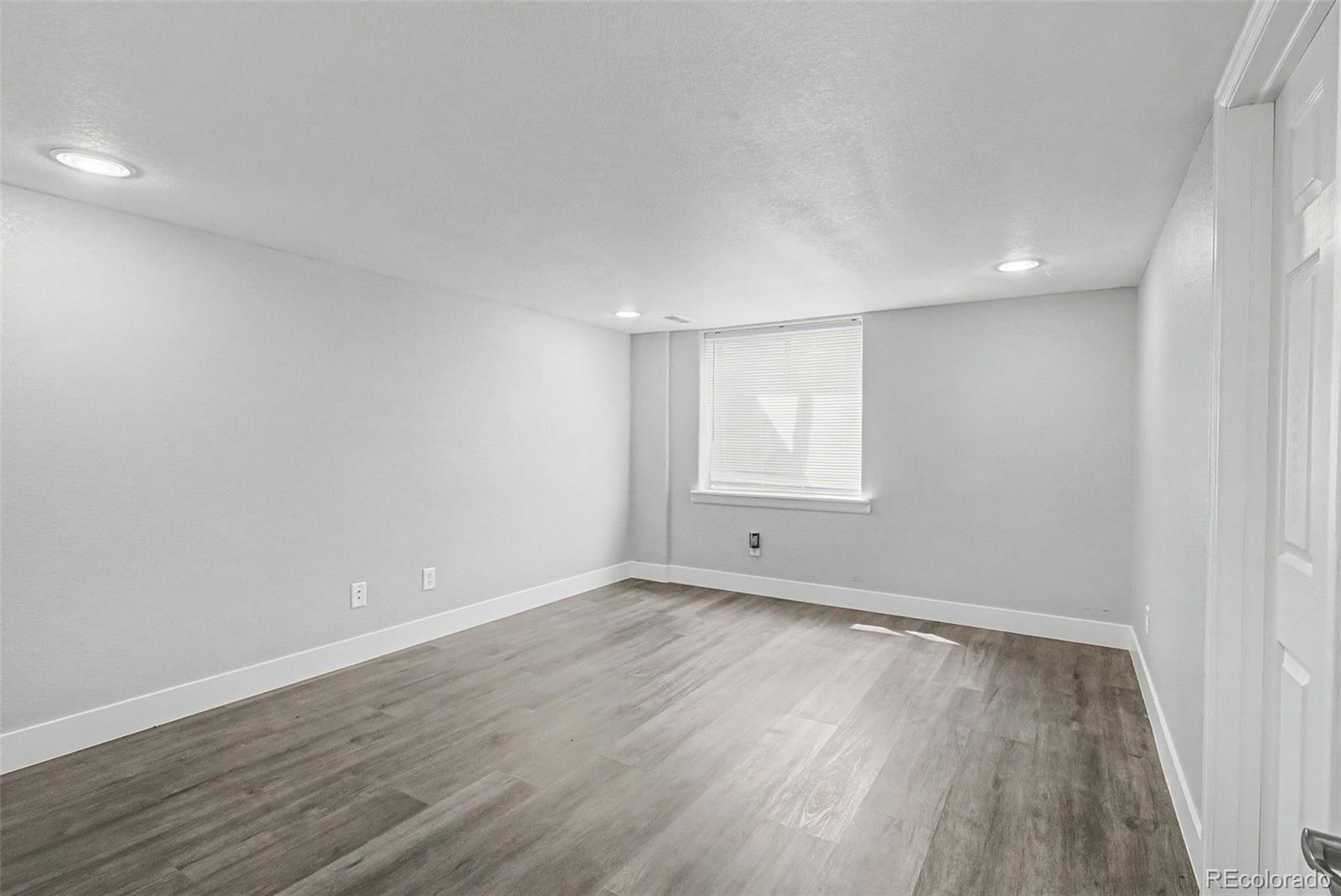 2233 70th Avenue Greeley, CO 80634 - Photo 36 of 50 a view of an empty room with wooden floor and a window