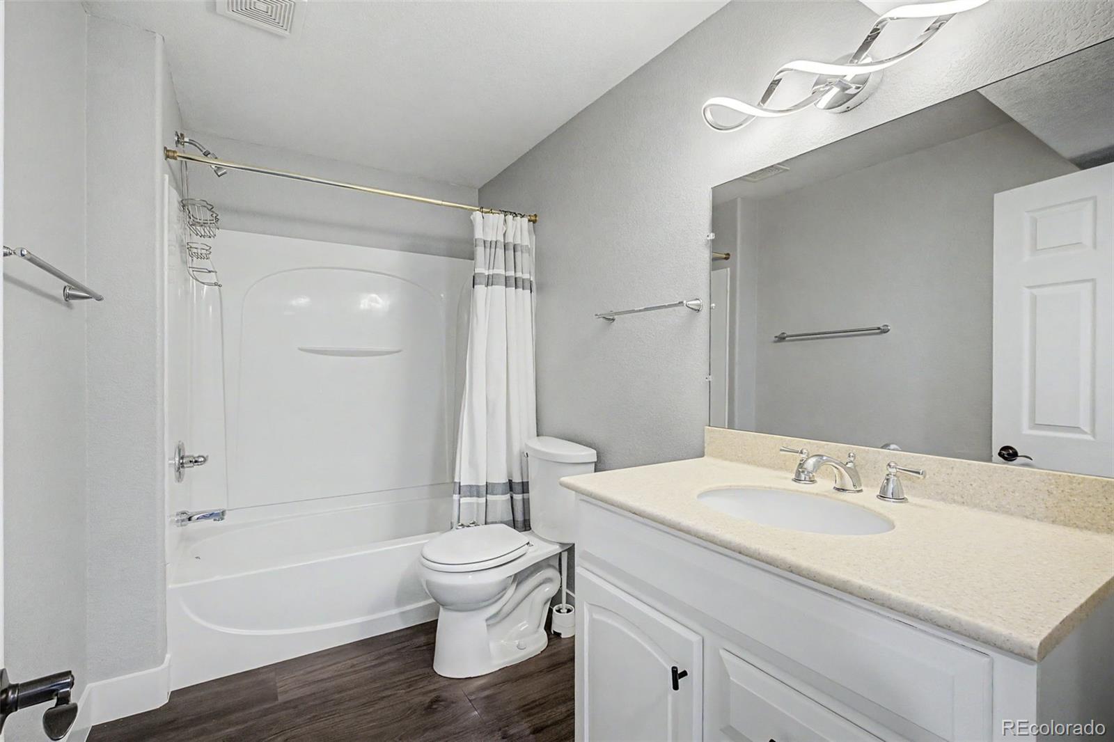 2233 70th Avenue Greeley, CO 80634 - Photo 39 of 50 a bathroom with a sink a toilet and a large mirror