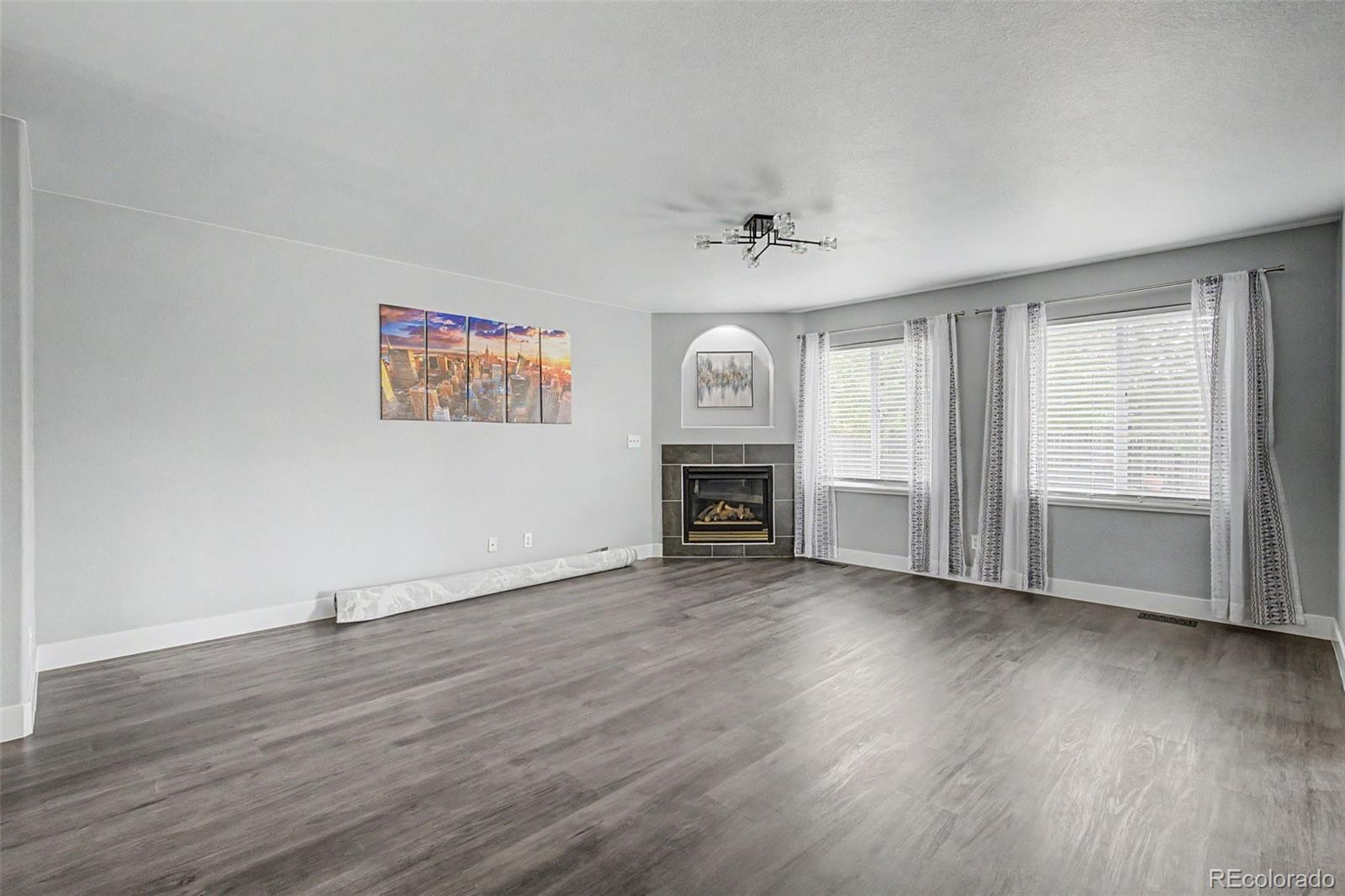 2233 70th Avenue Greeley, CO 80634 - Photo 6 of 50 a view of empty room with wooden floor and fireplace