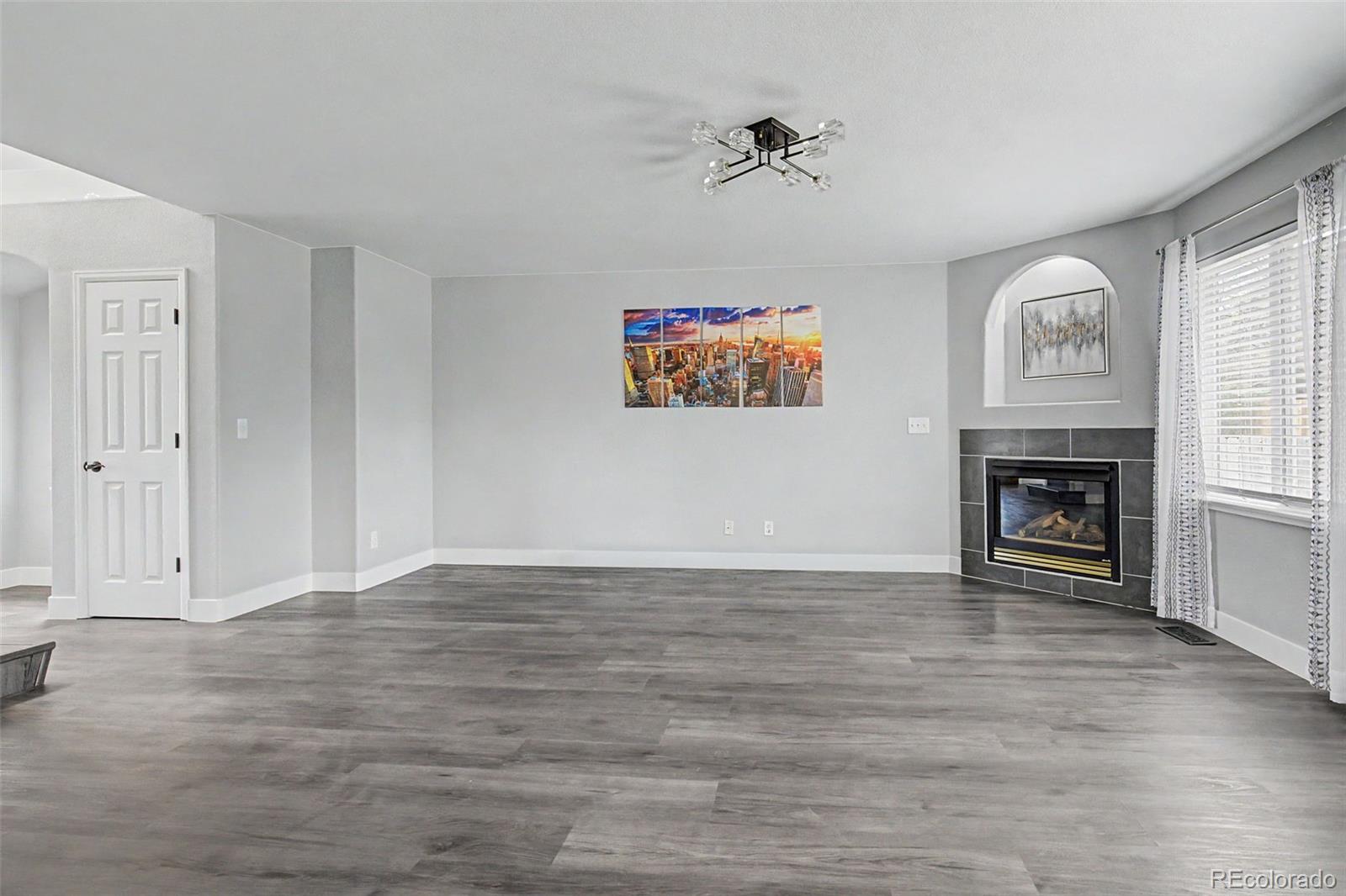 2233 70th Avenue Greeley, CO 80634 - Photo 7 of 50 a view of an empty room with a fireplace and a window