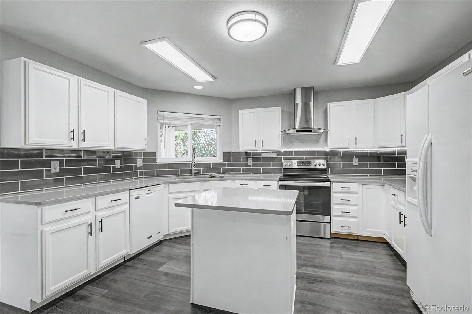 2233 70th Avenue Greeley, CO 80634 - Photo 9 of 50 a kitchen with granite countertop white cabinets and white appliances