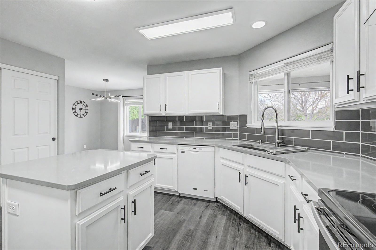 2233 70th Avenue Greeley, CO 80634 - Photo 10 of 50 a kitchen with granite countertop a sink stove and cabinets