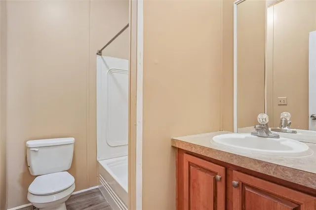 a bathroom with a granite countertop sink toilet and a mirror