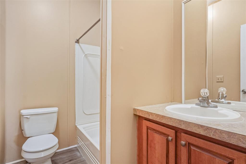 331 Prairie Lane Azle, TX 76020 - Photo 14 of 19 a bathroom with a granite countertop sink toilet and a mirror