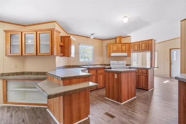 a kitchen with stainless steel appliances granite countertop a stove a sink and a refrigerator
