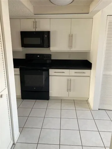 a view of kitchen with a microwave and cabinets