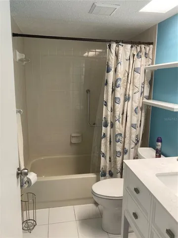 a bathroom with a granite countertop bathtub sink vanity mirror and toilet
