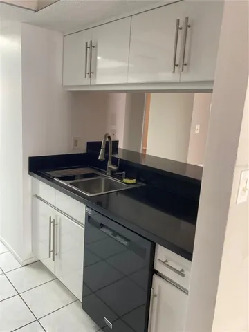 a kitchen with granite countertop white cabinets and black appliances