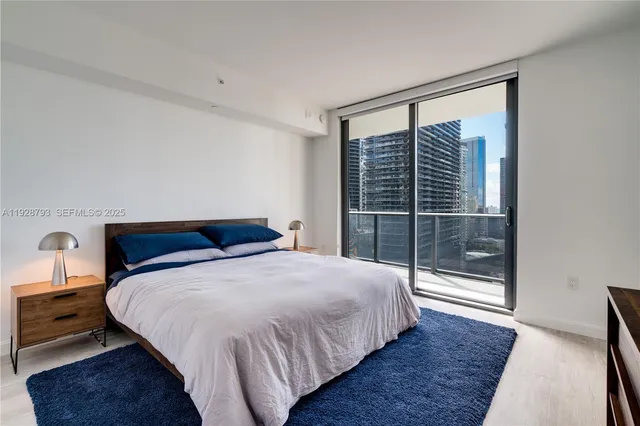 a bedroom with a bed and a large window