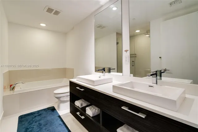 a large bed sitting in a bedroom next to a window