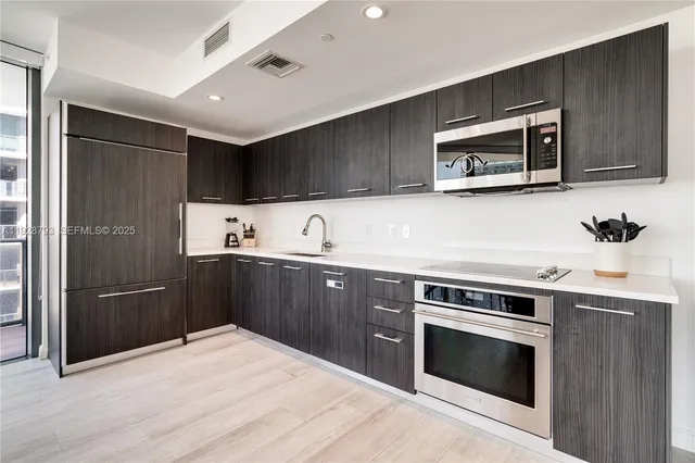 a kitchen with stainless steel appliances granite countertop a stove microwave and refrigerator