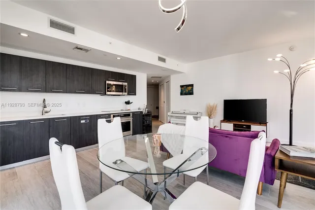 a living room with furniture a flat screen tv and kitchen view