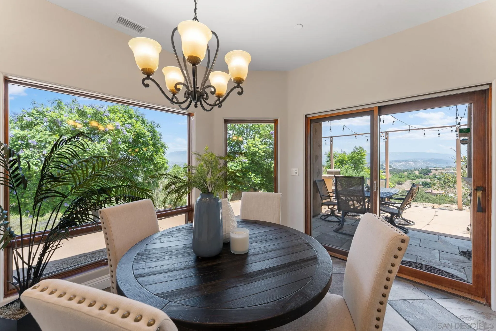12443 Mirar De Valle Road Valley Center, CA 92082 - Photo 12 of 54 a dining room with furniture a large window and a chandelier