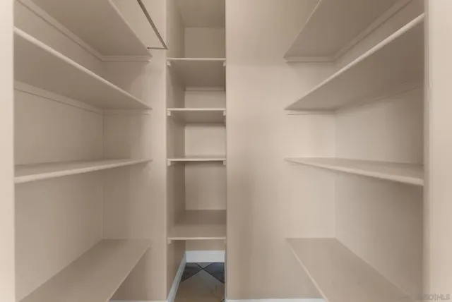 a view of walk in closet with empty racks