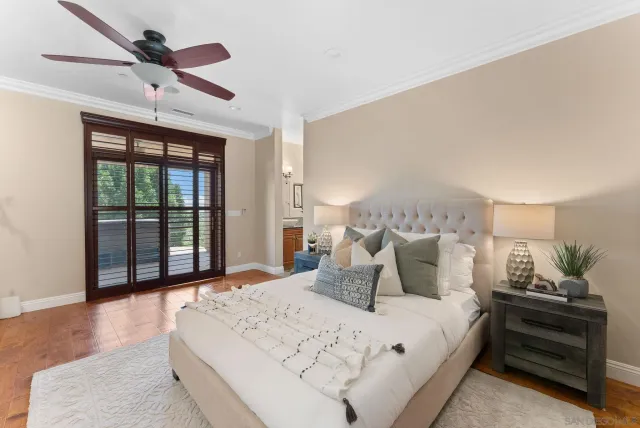 a bedroom with a large bed and a chandelier fan