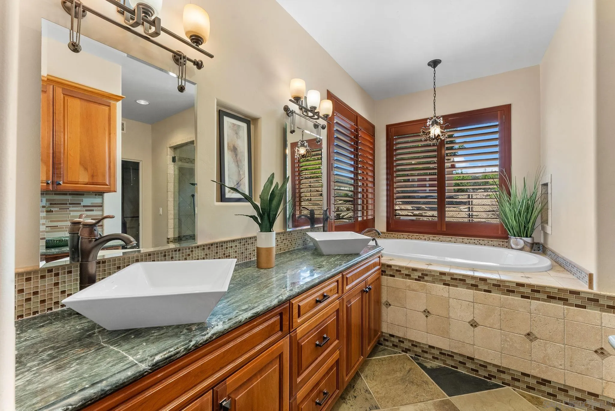 12443 Mirar De Valle Road Valley Center, CA 92082 - Photo 19 of 54 a bathroom with a granite countertop sink a large mirror and a bathtub next to a window