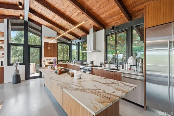 a large kitchen with kitchen island a large window in it
