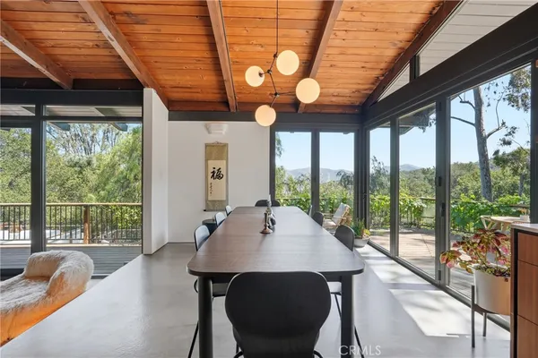a view of a dining room with furniture large windows and wooden floor