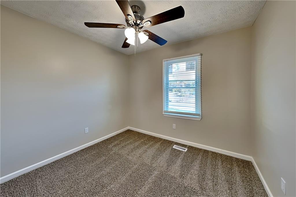 42 Breckenridge Drive Powder Springs, GA 30127 - Photo 14 of 24 an empty room with a window and a fan