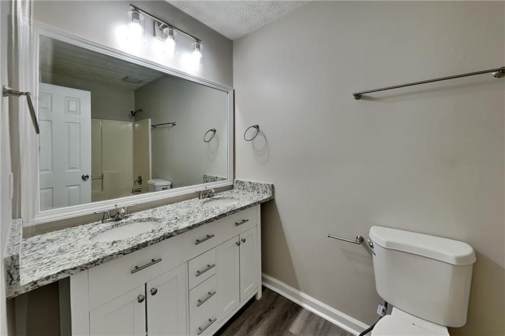 42 Breckenridge Drive Powder Springs, GA 30127 - Photo 16 of 24 a bathroom with a granite countertop sink a toilet and a mirror