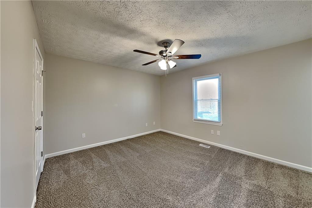 42 Breckenridge Drive Powder Springs, GA 30127 - Photo 7 of 24 an empty room with windows and ceiling fan