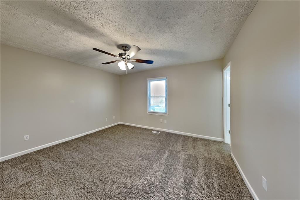 42 Breckenridge Drive Powder Springs, GA 30127 - Photo 8 of 24 an empty room with a chandelier fan and windows