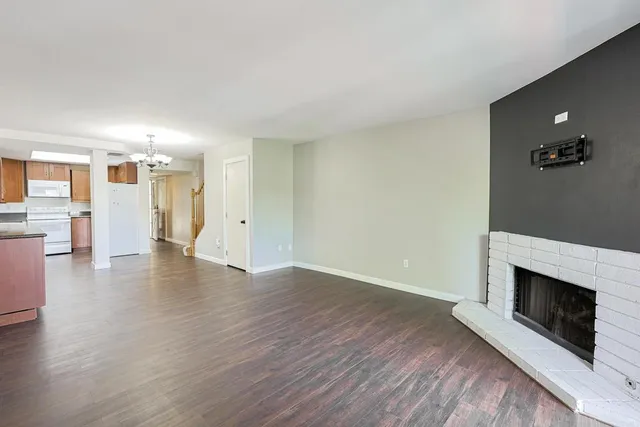 a view of a livingroom with wooden floor and a fireplace