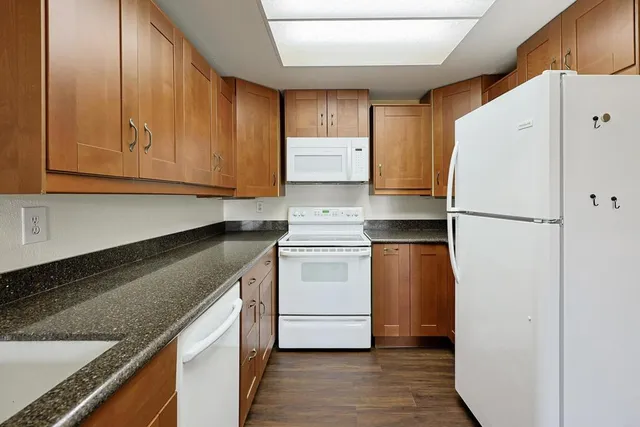 a kitchen with a refrigerator sink and cabinets