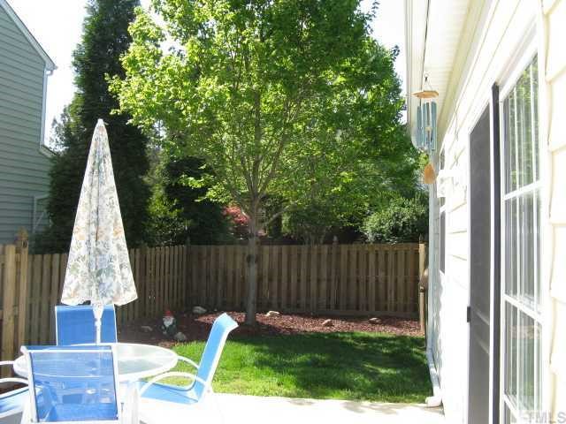 101 Rocca Circle Raleigh, NC 27603 - Photo 6 of 7 a view of backyard with table and chairs and wooden fence