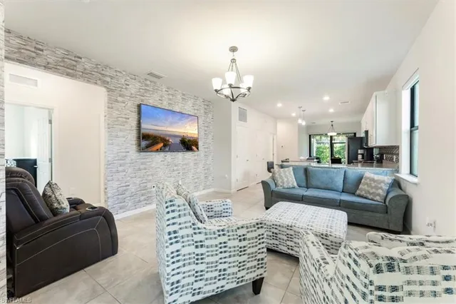 a living room with furniture a flat screen tv and kitchen view