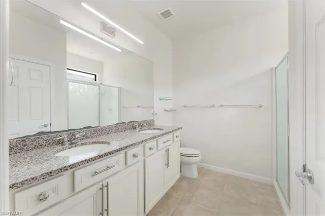 a bathroom with a granite countertop sink a toilet and a mirror