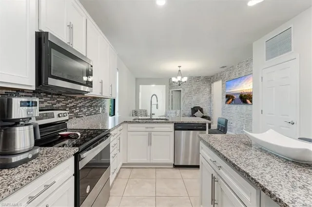 a kitchen with stainless steel appliances granite countertop a sink stove and microwave