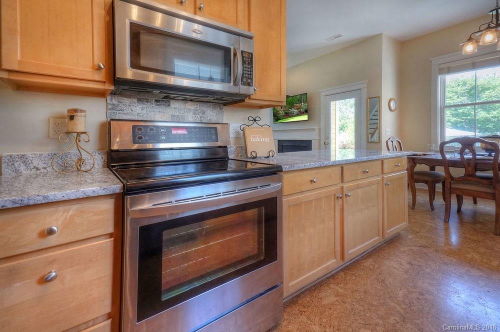 8117 Strandhill Road Huntersville, NC 28078 - Photo 13 of 36 a kitchen with granite countertop a stove top oven microwave and cabinets